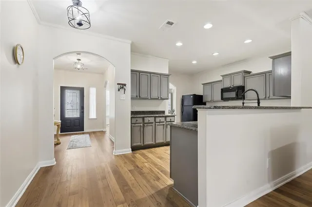a kitchen with stainless steel appliances granite countertop a sink refrigerator and cabinets