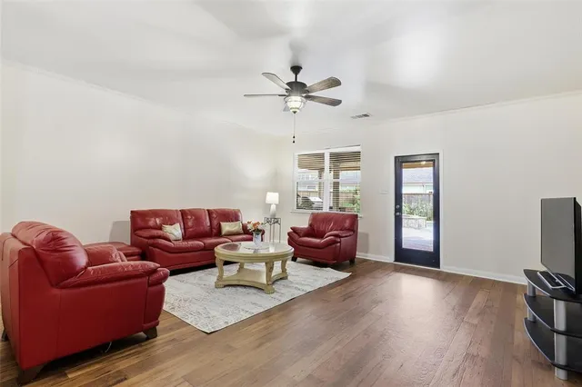 a living room with furniture a ceiling fan and a window