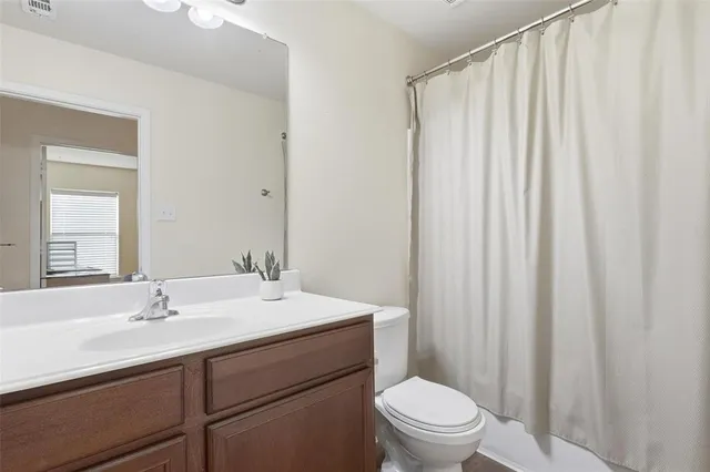 a bathroom with a sink a toilet and shower curtain