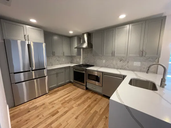 a kitchen with stainless steel appliances granite countertop a refrigerator a sink a stove a microwave and island