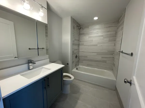 a bathroom with a double vanity sink toilet mirror and shower