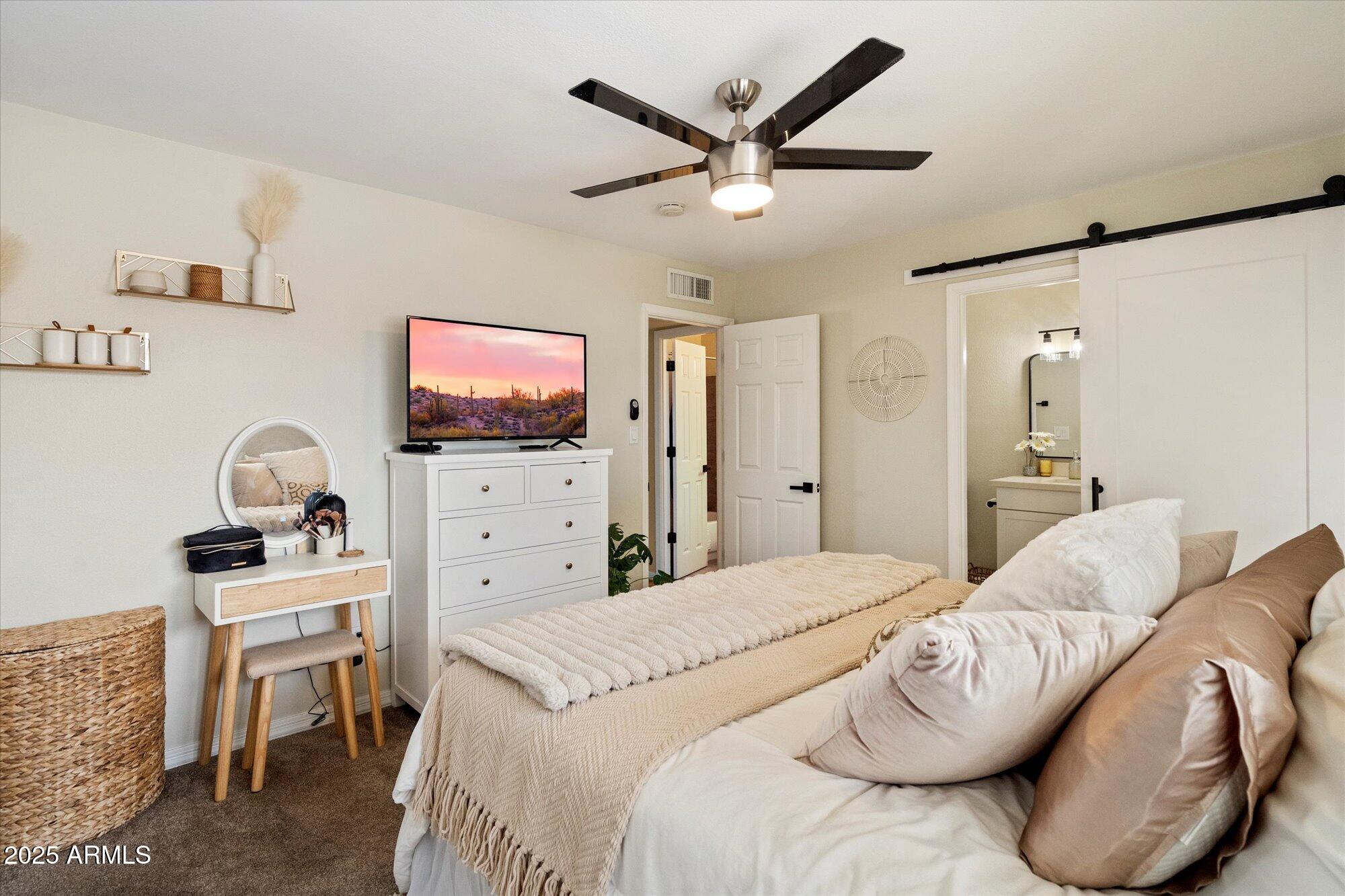 6005 North Granite Reef Road Scottsdale, AZ 85250 - Photo 7 of 19 a spacious bedroom with a bed furniture and a flat screen tv