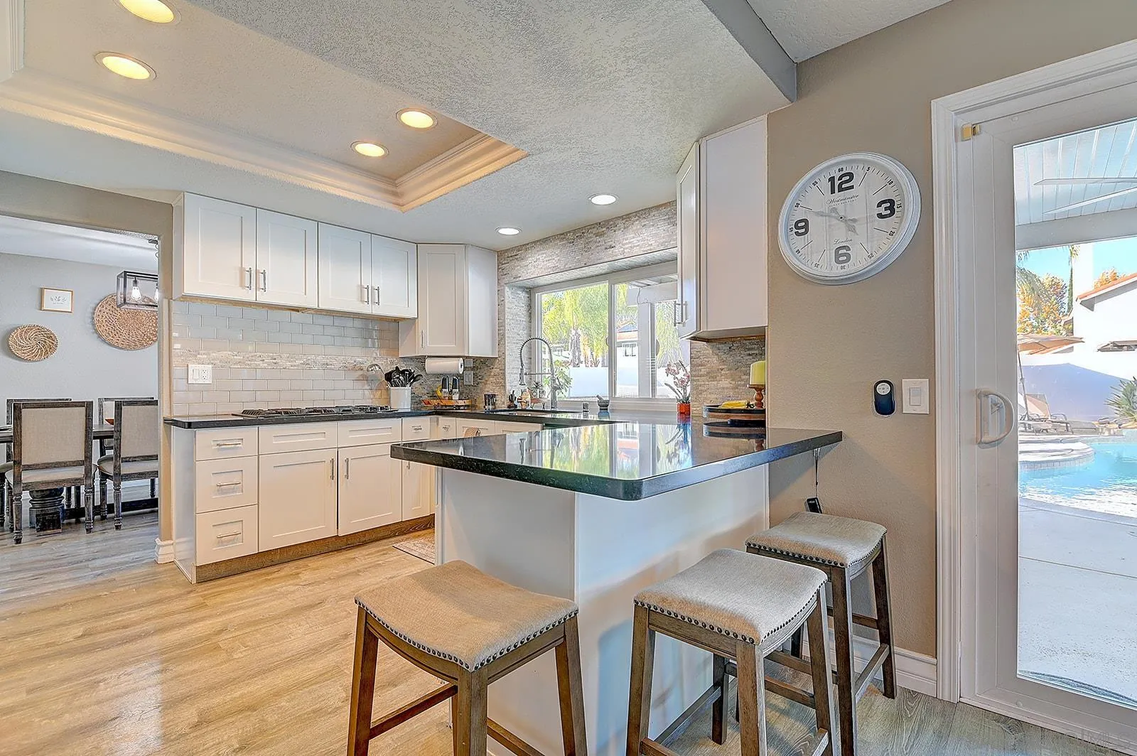 45774 Hopactong Street Temecula, CA 92592 - Photo 12 of 26 a kitchen with granite countertop a table chairs a stove a dining table and chairs