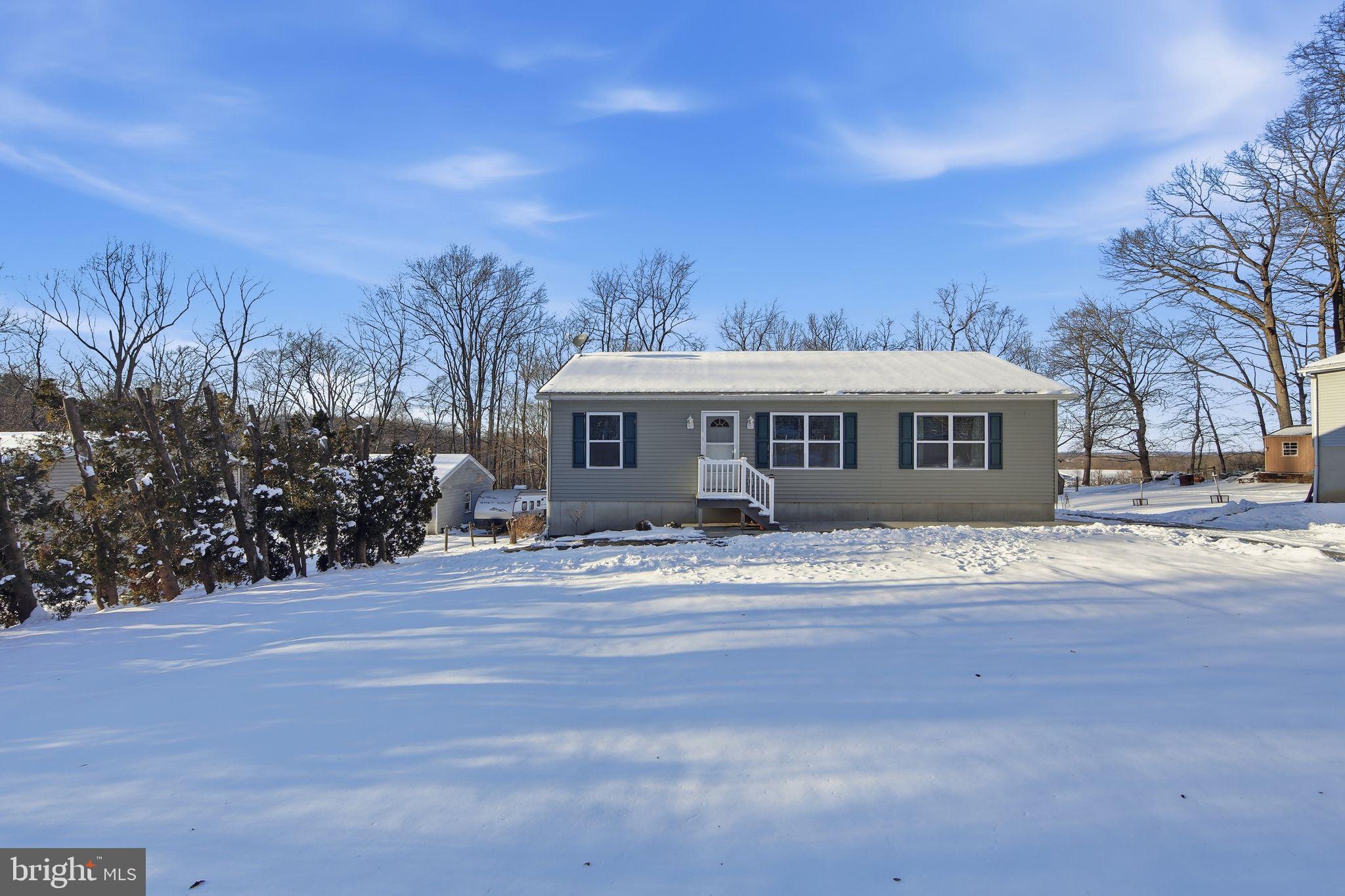 a front view of house with yard and trees around