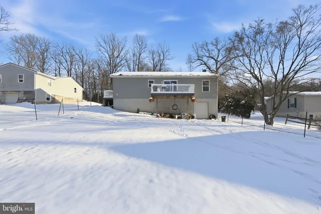 a view of a white house with a yard covered in snow