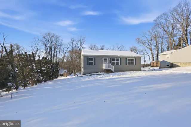 a front view of a house with a yard and trees