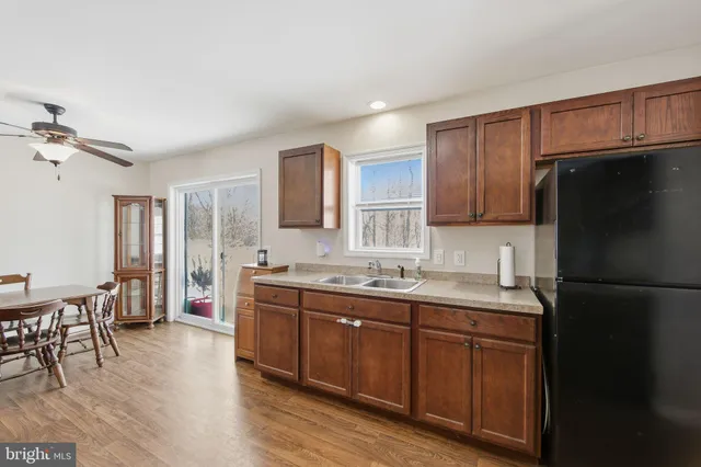 a kitchen with a sink a refrigerator and wooden cabinets