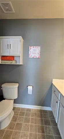 a bathroom with a toilet a sink and cabinets