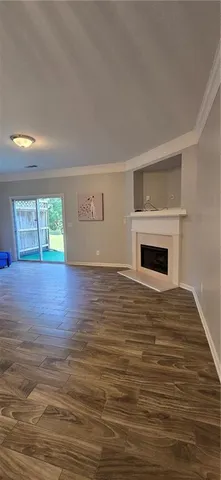 a view of empty room with wooden floor and fireplace