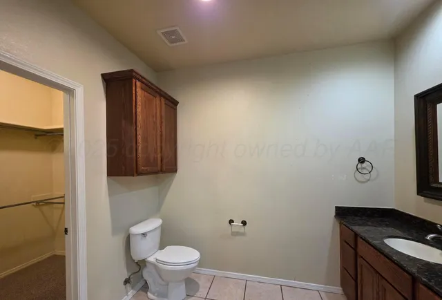 a bathroom with a granite countertop sink toilet and mirror