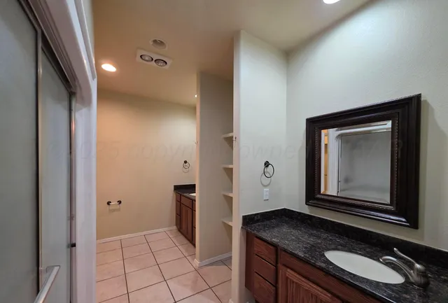 a bathroom with a granite countertop sink a mirror and vanity
