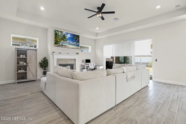 a living room with furniture and a large window with kitchen view