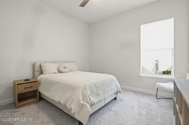 a bedroom with a bed and a large window