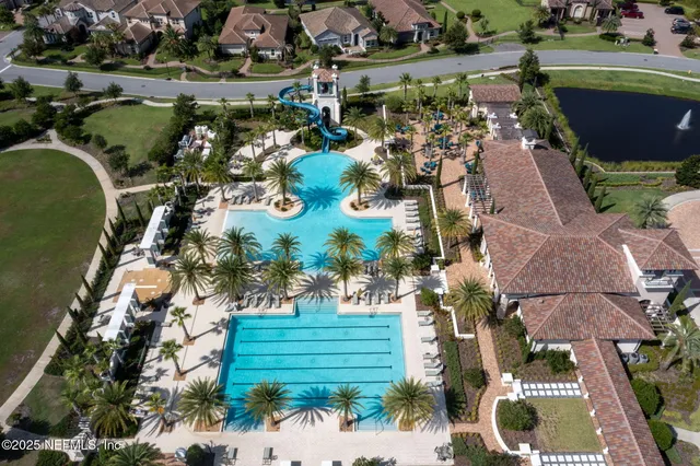 an aerial view of a house with a garden and lake view
