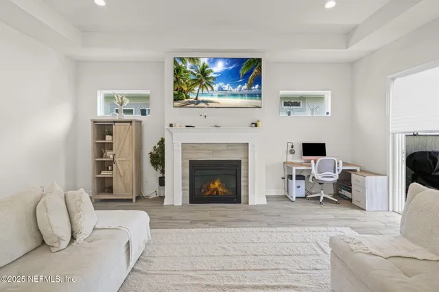 a living room with furniture a fireplace and a flat screen tv