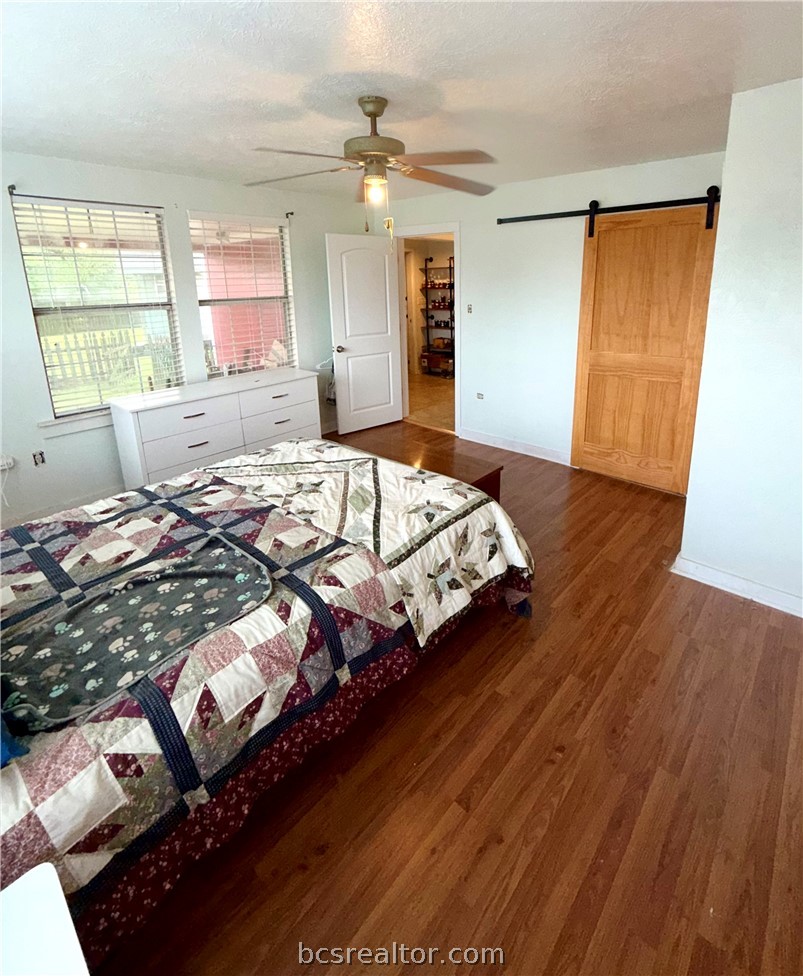 421 South Commerce Street Centerville, TX 75833 - Photo 16 of 23 a bedroom with a bed and wooden floor