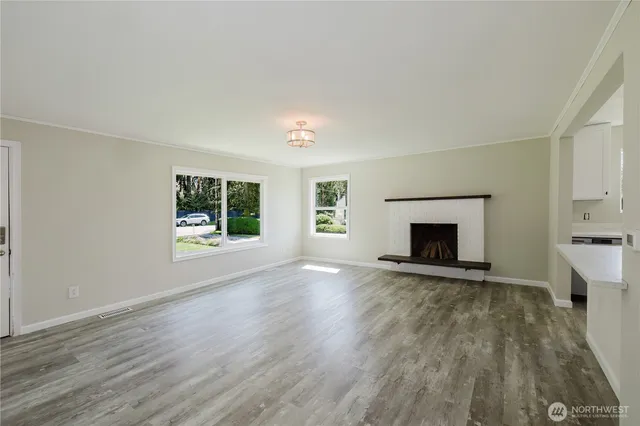wooden floor fireplace and windows in an empty room