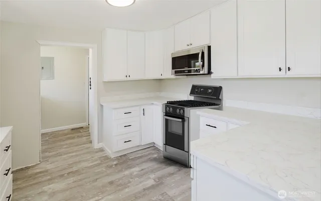 a kitchen with white cabinets and stainless steel appliances
