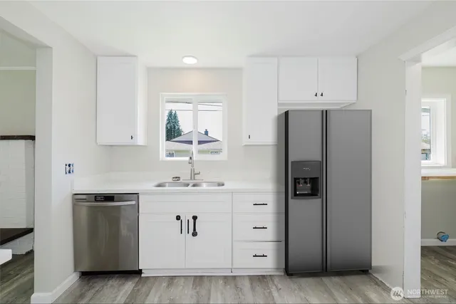 a kitchen with stainless steel appliances a refrigerator sink and cabinets