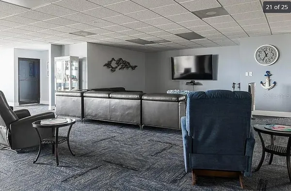 a living room with furniture a flat screen tv and kitchen view