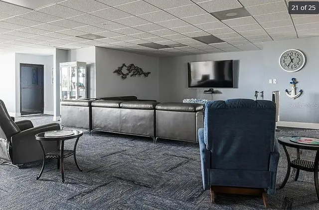 a living room with furniture a flat screen tv and kitchen view