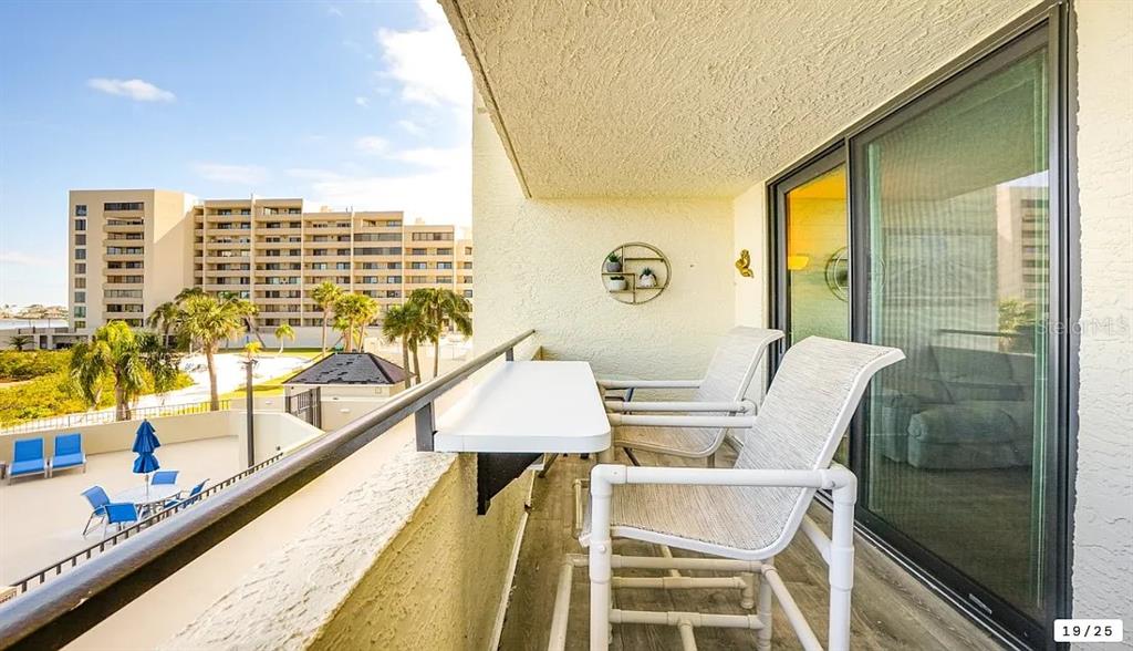6009 Sea Ranch Drive, Unit 208 Hudson, FL 34667 - Photo 3 of 22 view of balcony with wooden floor and outdoor seating