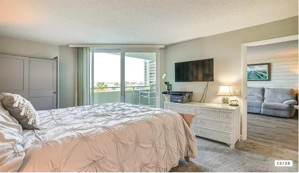a bedroom with a large bed and a flat screen tv