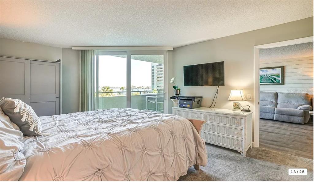 6009 Sea Ranch Drive, Unit 208 Hudson, FL 34667 - Photo 10 of 22 a bedroom with a large bed and a flat screen tv