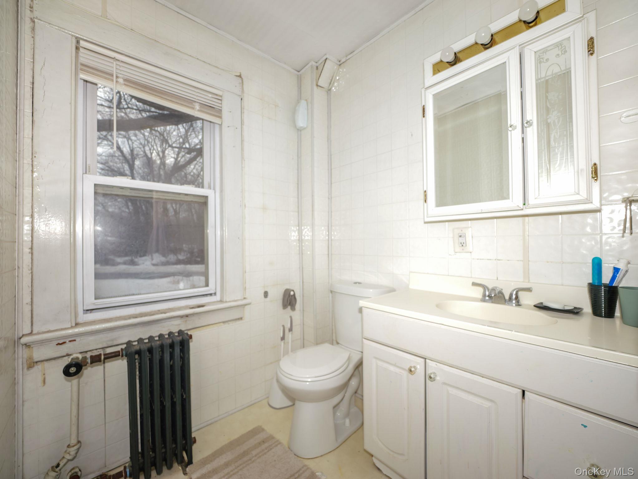 809 South Street Newburgh, NY 12550 - Photo 38 of 45 a bathroom with a toilet a sink and a mirror