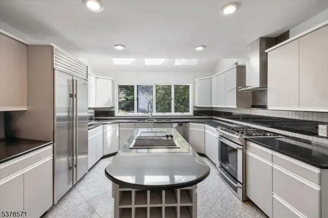 a kitchen with kitchen island white cabinets and stainless steel appliances