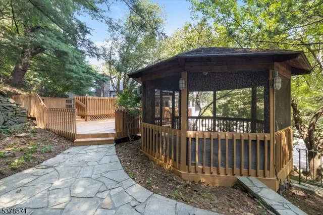 a view of a wooden deck and a yard with the trees