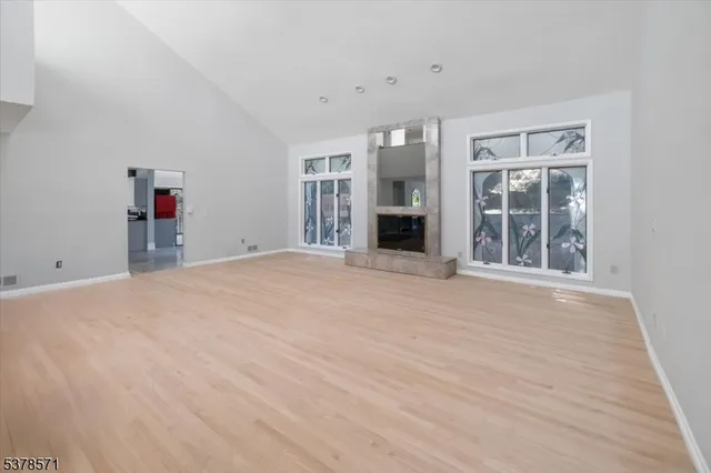 a view of empty room with wooden floor and window