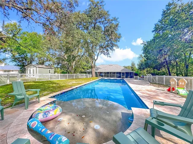 a view of swimming pool with a back yard and swimming pool