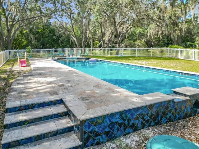 an aerial view of a house with a yard basket ball court and outdoor seating