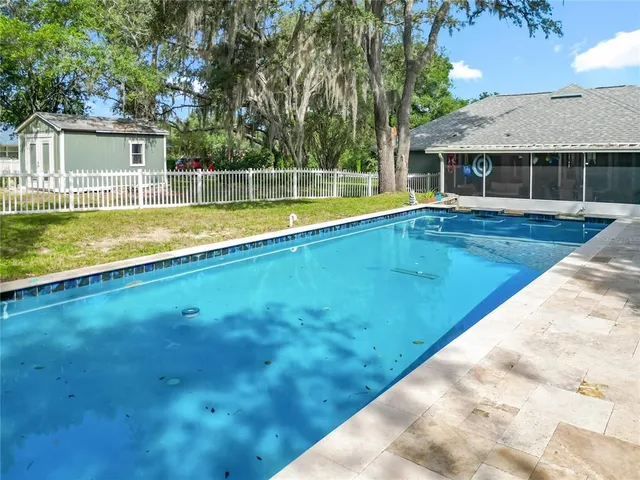 an aerial view of residential house with outdoor space and trees all around