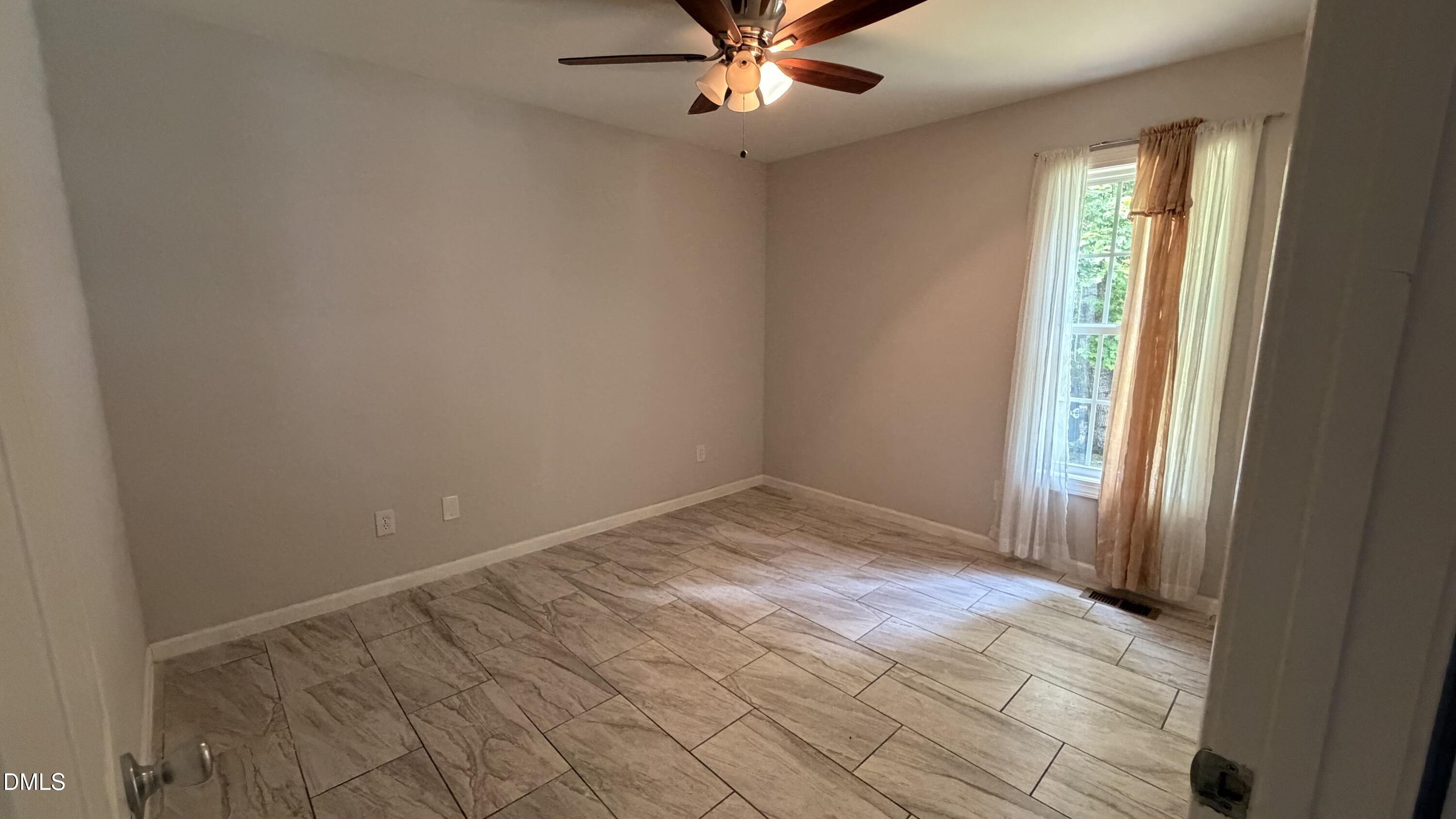 229 Sterling Way Angier, NC 27501 - Photo 4 of 10 an empty room with fan and windows