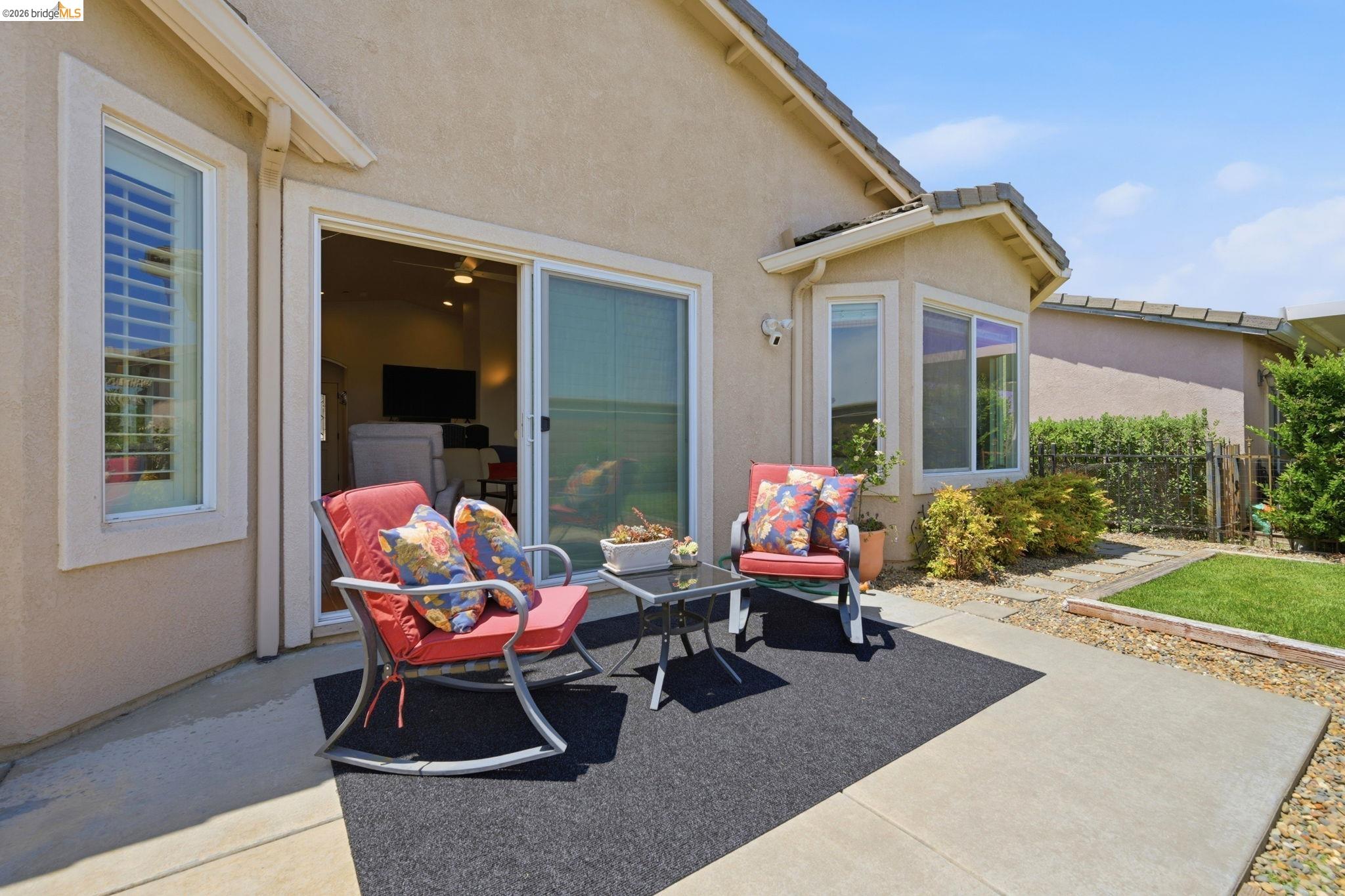 1024 Diamante Rio Vista, CA 94571 - Photo 23 of 27 Outdoor patio featuring a concrete slab, sliding glass door, and a grass lawn with surrounding shrubs