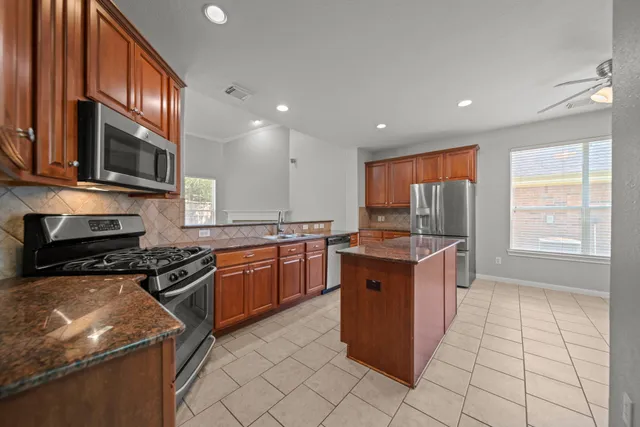 a kitchen with a sink refrigerator and microwave