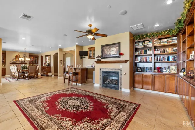 a living room with fireplace furniture and a kitchen view
