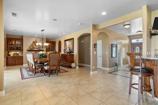 a kitchen with stainless steel appliances granite countertop a table chairs sink and wooden floor