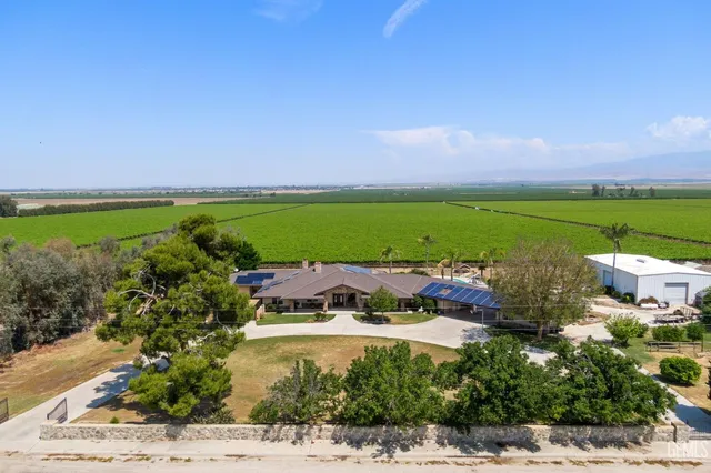 a view of swimming pool with outdoor seating and trees in the background