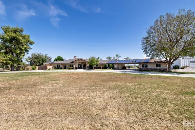 a view of a house with a big yard and potted plants