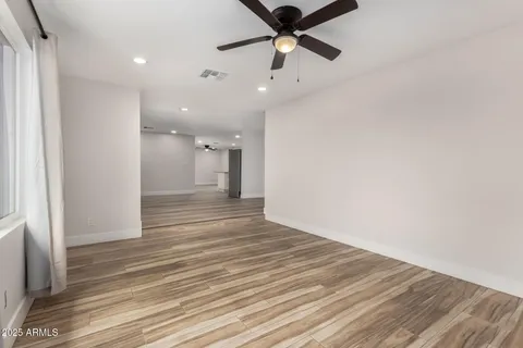 a view of a room with wooden floor and a ceiling fan