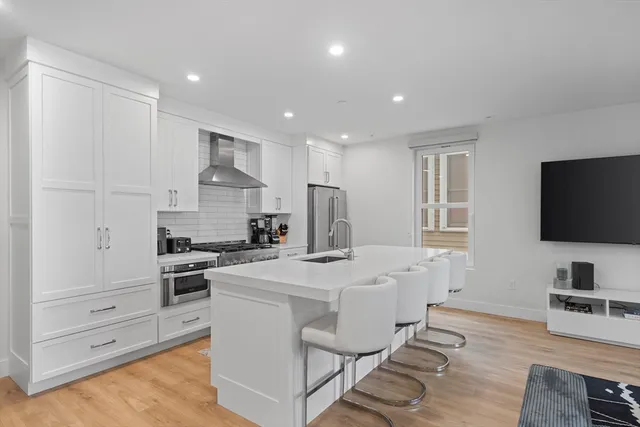 a kitchen with white cabinets and stainless steel appliances
