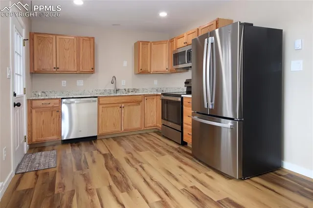 a kitchen with granite countertop stainless steel appliances a refrigerator and a sink