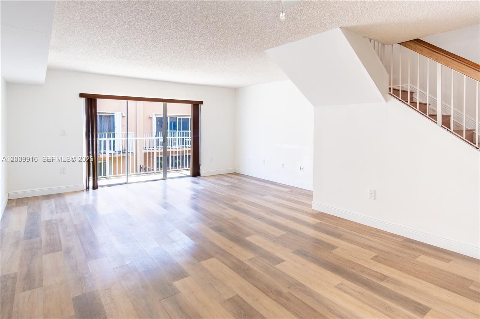 14905 Southwest 80th Street, Unit 212 Miami, FL 33193 - Photo 26 of 37 a view of an empty room with wooden floor and a window