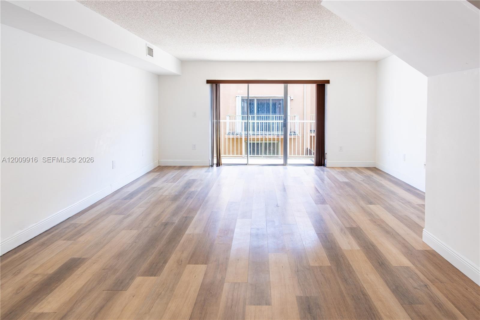 14905 Southwest 80th Street, Unit 212 Miami, FL 33193 - Photo 10 of 37 wooden floor in an empty room with a window