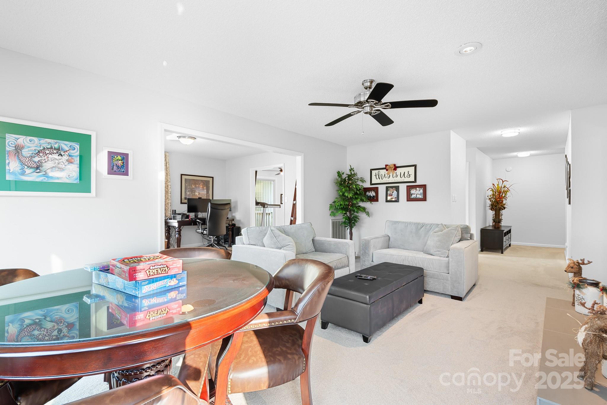 9044 Spanish Wells Court Tega Cay, SC 29708 - Photo 23 of 48 a living room with furniture a chandelier and a dining table