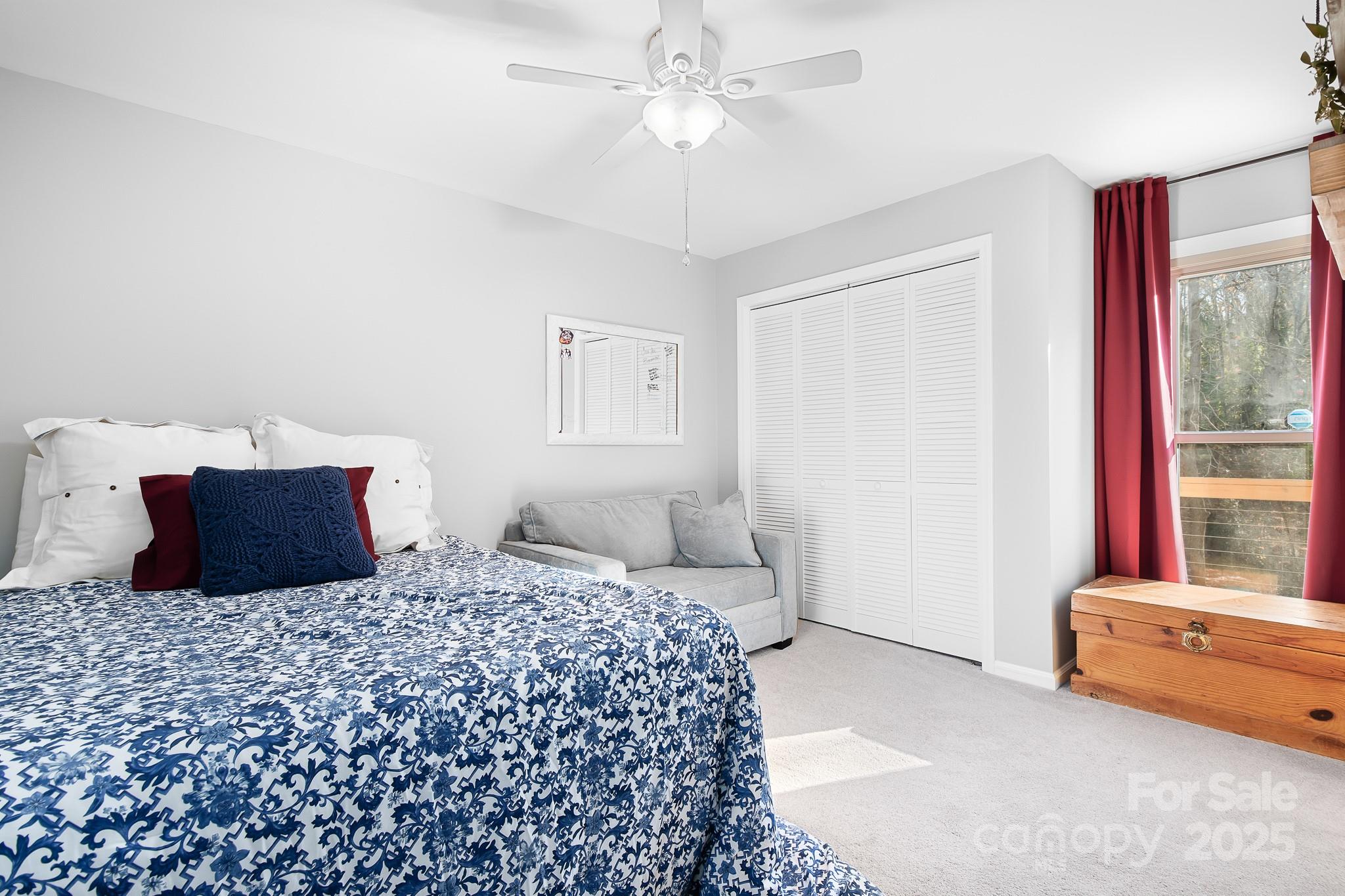 9044 Spanish Wells Court Tega Cay, SC 29708 - Photo 27 of 48 a bedroom with a large bed and a chandelier