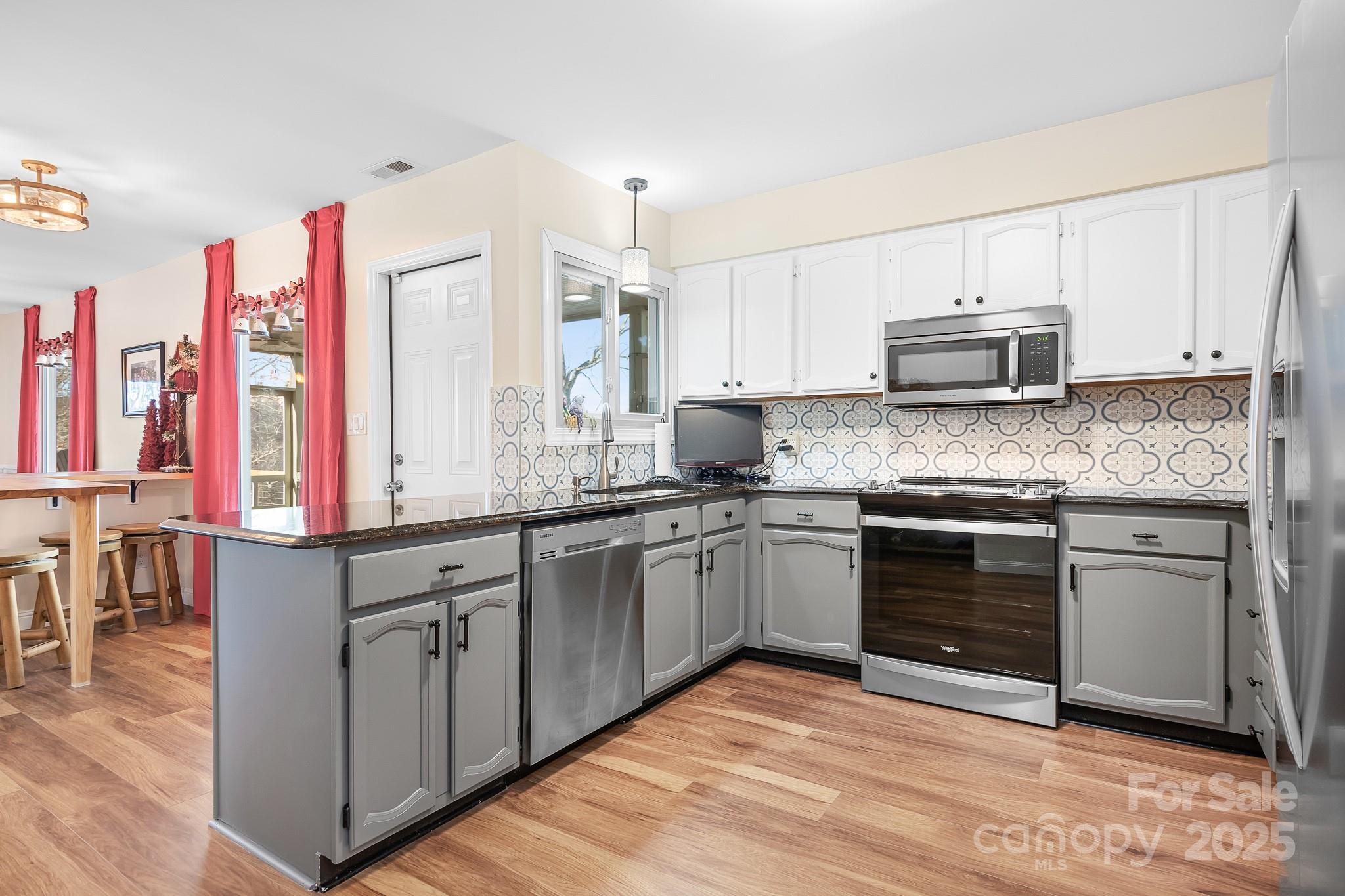 9044 Spanish Wells Court Tega Cay, SC 29708 - Photo 10 of 48 a kitchen with stainless steel appliances granite countertop a stove sink and cabinets